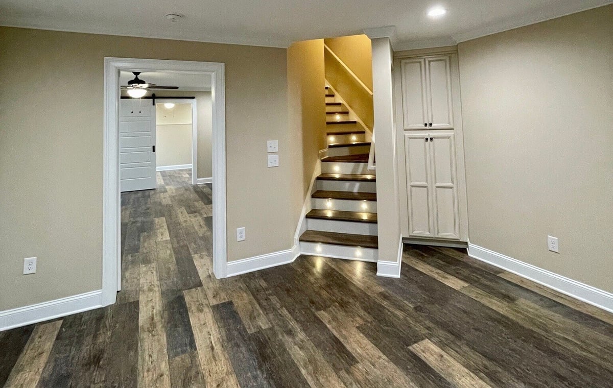 Remodeled basement with wood plank flooring and built-in cabinet storage